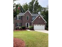 Two story brick home with a white double garage door at 4670 Wynnmeade Sw Ln, Lilburn, GA 30047