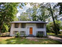 Charming ranch-style home with white brick exterior and orange door at 3296 Conestoga Trl, Marietta, GA 30060