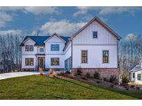 Two-story house with white siding, brick accents, and a three-car garage at 4640 Callan Trl, Cumming, GA 30041