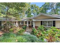 Charming ranch home with stone walkway and manicured lawn at 5775 Lakeshore Dr, Buford, GA 30518
