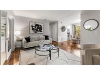 Bright living room with hardwood floors, neutral decor, and a view into the dining area at 46 Monet Nw Ct, Atlanta, GA 30327