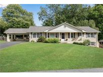 Brick ranch house with carport and well-manicured lawn at 3216 Guynelle Dr, Marietta, GA 30066