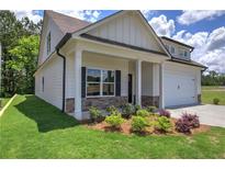 Cream-colored house with a front porch, stone accents, and a two-car garage at 111 Sunflower Ne Cir, Cartersville, GA 30121