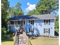 Two story light blue house with a wraparound porch and a wooden walkway at 2598 Canon Sw Dr, Marietta, GA 30064