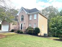 Two story home with manicured lawn and landscaping at 221 Larkshyre Trl, Lawrenceville, GA 30043