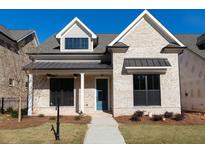 Brick home with a metal roof, a blue door, and landscaping at 2753 Evanshire Ave, Duluth, GA 30096