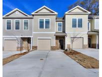 Tan and gray townhouses with attached garages and landscaping at 6206 Ripple Way # 89, South Fulton, GA 30349