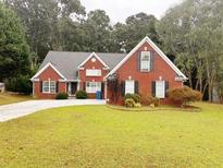 Brick house with a two-car driveway and landscaped lawn at 2290 Taylor Pointe Way, Dacula, GA 30019