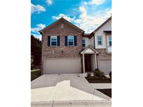 Two story brick and white townhome with two-car garage at 1433 Ben Park Way, Grayson, GA 30017