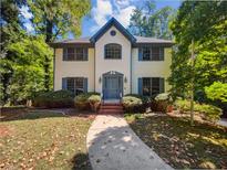 Two-story house with white brick exterior, gray shutters, and a landscaped yard at 709 Tribal Trl, Woodstock, GA 30188