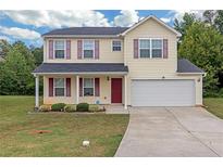 Two-story house with a two-car garage and front porch at 7107 Tanger Blvd, Riverdale, GA 30296