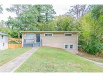 Tan brick ranch house with gray steps and landscaping at 1278 Lynwyn Se Ln, Atlanta, GA 30316