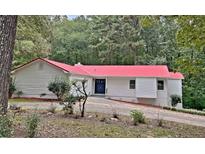 House exterior with a red metal roof, white siding, and landscaping at 226 Oak Hill Ct, Lithia Springs, GA 30122