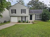 Two-story house with gray siding, a double-car garage, and a well-maintained lawn at 1378 Mill Lake Cir, Stone Mountain, GA 30088