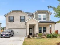 Two story home with brick facade and two-car garage at 719 Sara Meadow Rd, Loganville, GA 30052