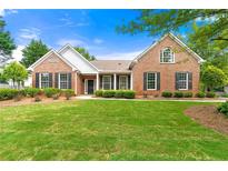 Brick house with a lush lawn, showcasing a welcoming front entrance at 1015 Forest Creek Dr, Canton, GA 30115