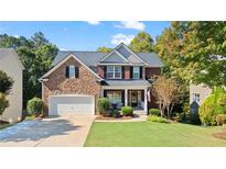 Brick two-story home with a landscaped lawn and attached garage at 551 Lincolnwood Ln, Acworth, GA 30101