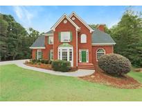 Brick two story house with green accents and large yard at 9508 Greens Mill Ct, Loganville, GA 30052