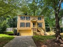 Two-story yellow house with a large yard and attached garage at 435 Ridgedale Way, Lawrenceville, GA 30044