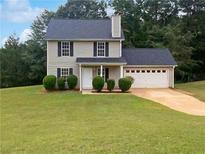 Charming two-story house with a two-car garage and manicured lawn at 9105 Sterling Lakes Cir, Covington, GA 30014