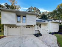 Two-story home with a two-car garage and brick walkway at 3624 Nessa Se Ct, Smyrna, GA 30082