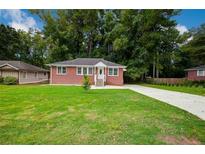 Brick Ranch home with a large front yard, driveway, and landscaping at 690 Green Acres Se Rd, Smyrna, GA 30080