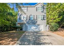 Two-story gray sided home with a two-car garage and a welcoming front entrance at 280 Green Commons Dr, Covington, GA 30016