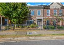 Front view of brick townhome with landscaping and black fence at 910 Westmoreland Nw Cir, Atlanta, GA 30318