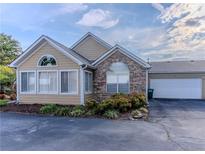 Tan house with stone accents, attached garage, and landscaping at 2191 Rockbridge Rd # 501, Stone Mountain, GA 30087