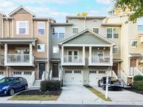 Townhome exterior featuring two-story design, attached garage, and inviting front porch at 1268 Liberty Nw Pkwy, Atlanta, GA 30318