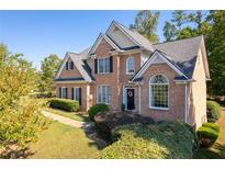 Brick two-story house with a gray roof and landscaping at 2600 Wells Sw Ter, Atlanta, GA 30331