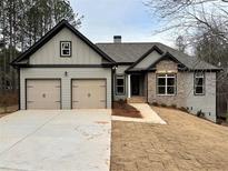 Charming two-story home with a two-car garage, brick and siding exterior, and landscaped yard at 5544 Whispering Swan Ct, Douglasville, GA 30135