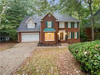 Brick two-story house with a two-car garage and landscaping at 1512 Maplewood Ct, Woodstock, GA 30189
