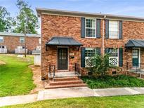 Brick townhouse with a covered entrance and small yard at 5696 Kingsport Dr # 3, Atlanta, GA 30342