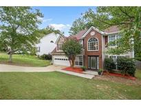 Two-story house with brick and siding, attached garage, and landscaped lawn at 721 Simon Park Cir, Lawrenceville, GA 30045