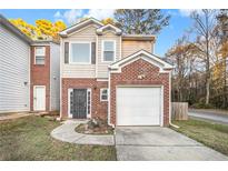 Brick townhouse with attached garage and well-maintained landscaping at 5100 Windsor Forrest Ln, Atlanta, GA 30349