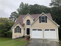 Two-story house with beige vinyl siding and a two-car garage at 7118 Brookstone Trl, Lithonia, GA 30058