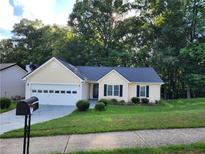 Charming yellow house with a two-car garage at 835 Amelia Grove Ln, Lawrenceville, GA 30045