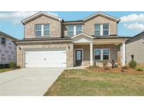 Two-story brick house with a white garage door and landscaped lawn at 7751 Plymouth Dr, Fairburn, GA 30213