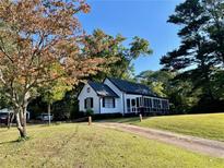 Charming white house with a screened porch and landscaped yard at 3970 Norman Rd, Stone Mountain, GA 30083