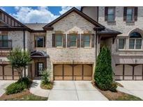 Brick townhouse with two-car garage and landscaping at 1175 Grassy Oat Ln, Lawrenceville, GA 30045
