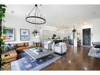 Open concept living room with hardwood floors, leather sectional sofa, and kitchen views at 360 Chambers St # 151, Woodstock, GA 30188