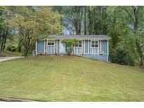 Ranch style home with a blue exterior and well-manicured lawn at 4649 Big Valley Ct, Stone Mountain, GA 30083