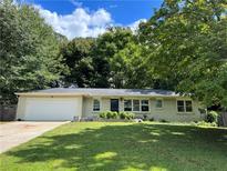 Brick ranch house with a white garage door and lush lawn at 2334 Elmwood Se Dr, Atlanta, GA 30339