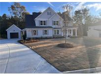 Two-story house with gray siding, stone accents, and a detached garage at 2719 Byess Ct, Marietta, GA 30064