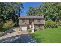 Two story house with attached garage and a green lawn at 4693 Hairston Crossing Rd, Stone Mountain, GA 30083