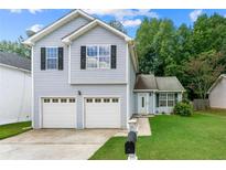 Two-story house with gray siding, double garage, and well-maintained lawn at 2565 Feywood Ct, Lithonia, GA 30058