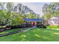 Charming ranch home with red front door and well-manicured lawn at 4323 Autumn Hill Dr, Stone Mountain, GA 30083