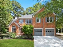 Brick two-story house with two-car garage and landscaped yard at 11385 Quailbrook Chase, Johns Creek, GA 30097