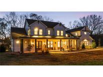 Stunning two-story farmhouse with a large front porch and expansive lawn at 4165 Milford Trl, Cumming, GA 30028